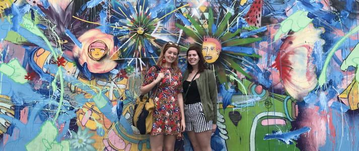 chelsea and friend in front of graffiti wall
