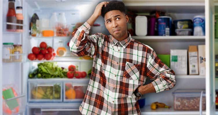 confused man in front of fridge and cupboard
