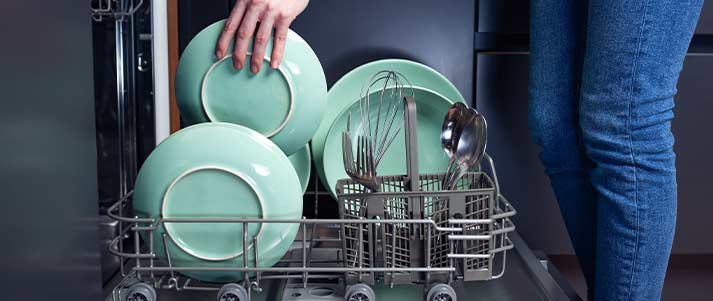 Woman using dishwasher
