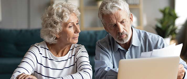  pareja de ancianos mirando la computadora portátil