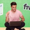 Man smiling at laptop with Fiverr logo and 5 pound note
