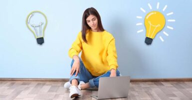 Woman at laptop with lightbulbs