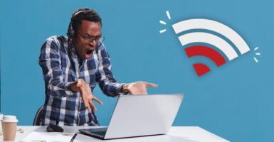 man frustrated at laptop next to wifi symbol