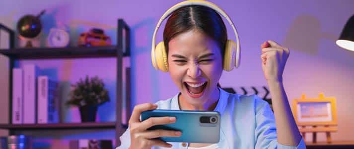 Girl playing games on phone with headphones
