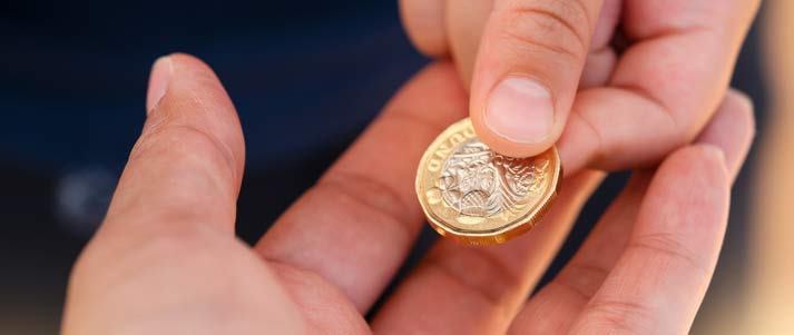 pound coin being given to someone