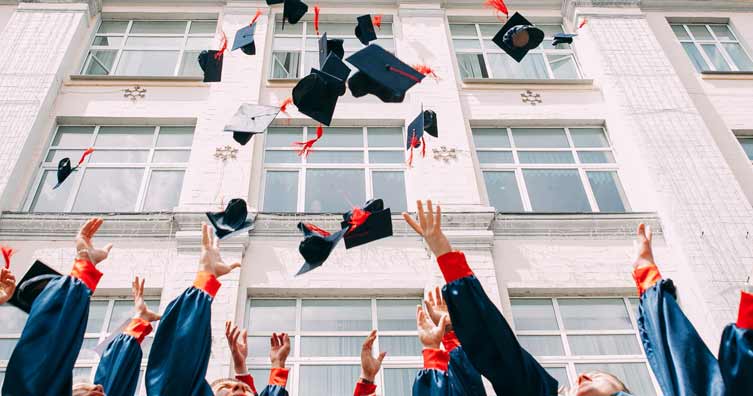 graduates throwing hats into the air