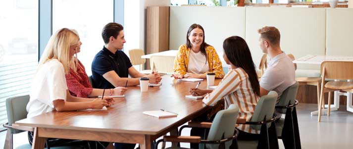 bir toplantıda masada oturan bir grup insan