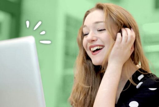 happy woman smiling looking at a laptop