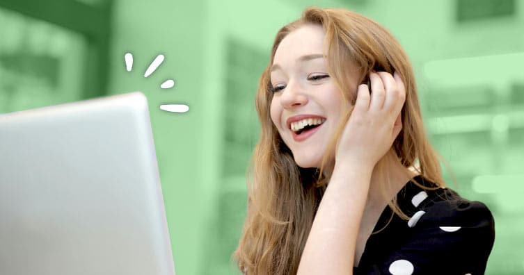 Happy woman smiling and looking at laptop