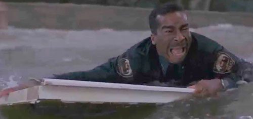 Flood scene from Jumanji - policeman floating in torrential water