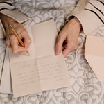 Woman handwriting a letter with envelope
