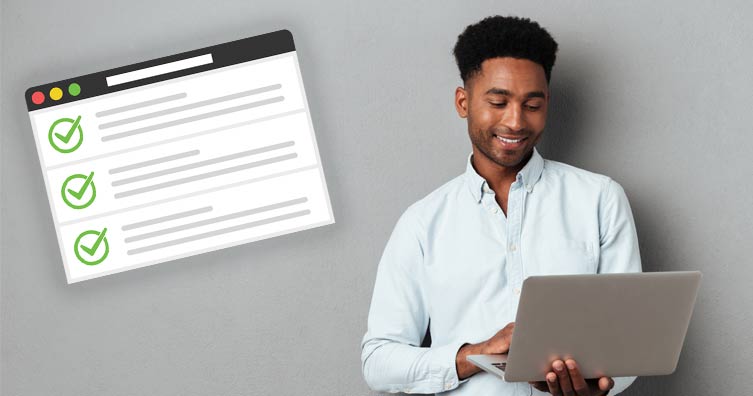 man using laptop next to job application form