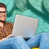 man using laptop with coins in background