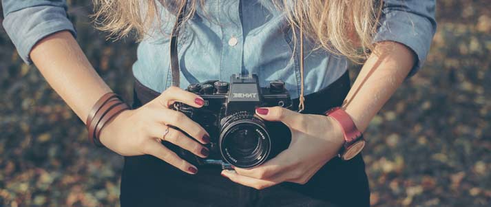 woman holding camera in front of her waist