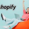 Woman using a laptop with Shopify logo