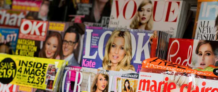 rows magazines on a shelf in a shop