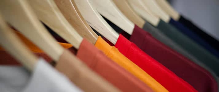 Colourful t-shirts on hangers
