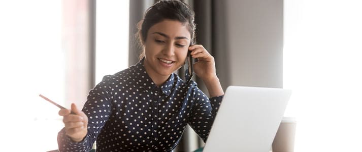 Girl at desk with laptop talking on headset