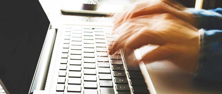 hands typing on a laptop