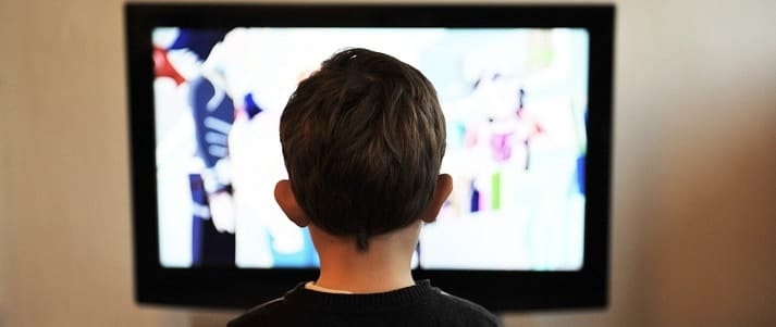 rear view of child watching television