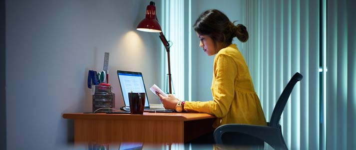 a woman writes an essay on a laptop