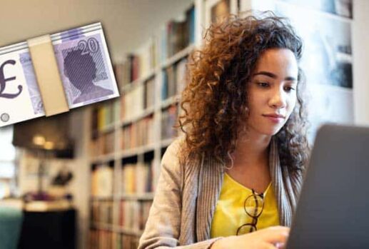 young woman sat using laptop next to money