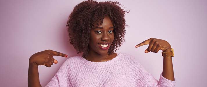 woman pointing at herself and smiling