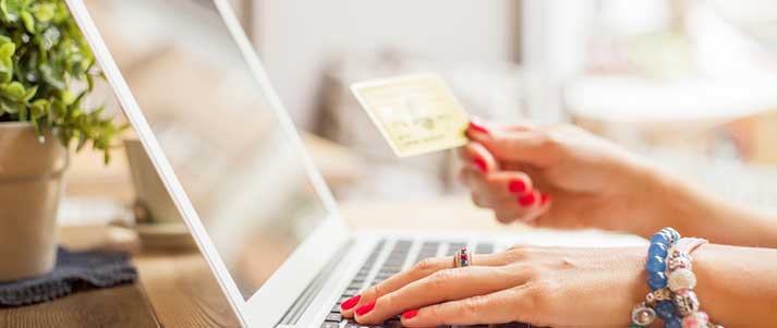 woman at laptop holding a credit card