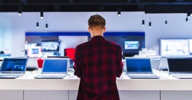 young person looking at laptops