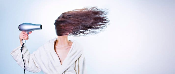 woman blowdrying her hair