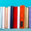 colourful books stacked against blue background