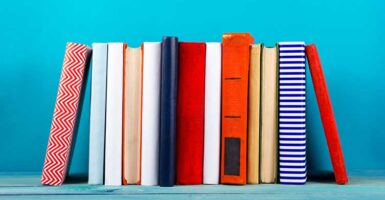 colourful books stacked against blue background