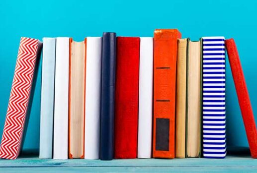 colourful books stacked against blue background