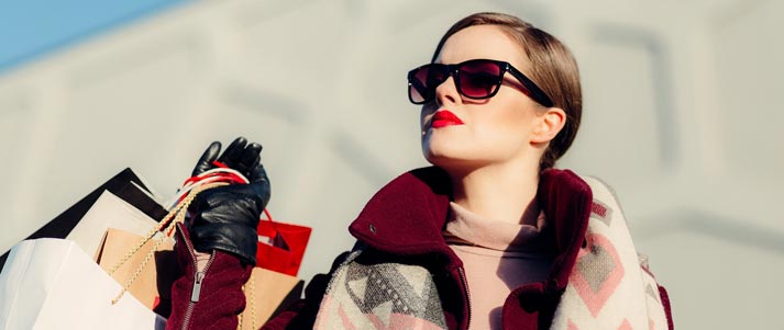 girl wearing sunglasses holding shopping bags