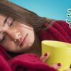 Woman in blanket with mug and coronavirus germ