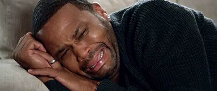 man crying on sofa