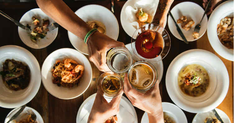 glasses above a table with plates of food