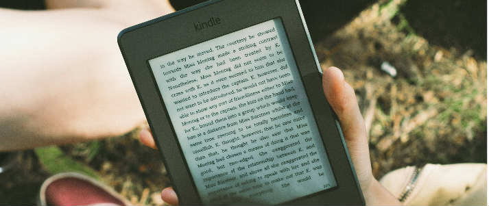 someone holding a black amazon kindle