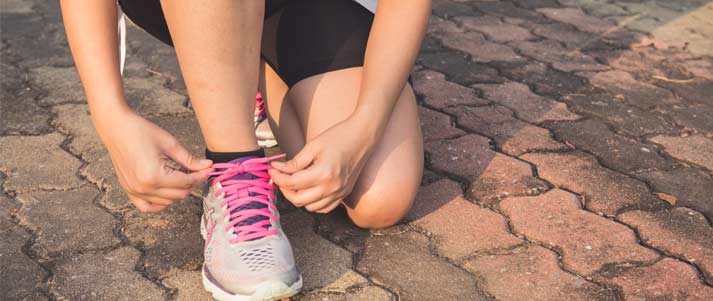 woman tying up trainer laces