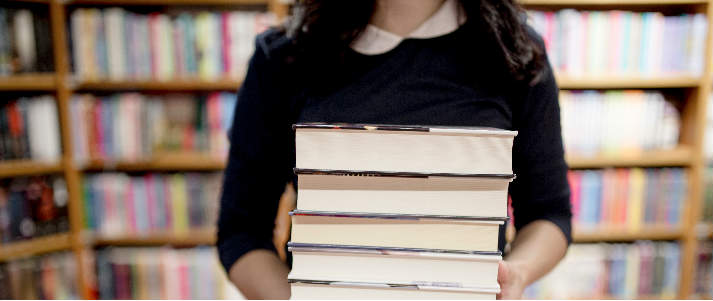 girl carrying stack of books