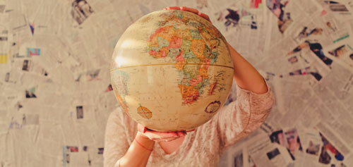 Girl standing behind giant inflatable globe