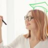 Woman writing on post it notes with drawn graduate cap