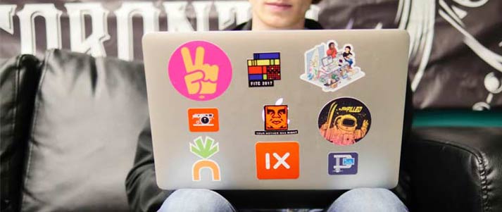 person using laptop with stickers