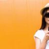 girl in hat holding scrolling phone