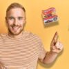 man holding cash and pointing to hotwheels, books and pokemon card
