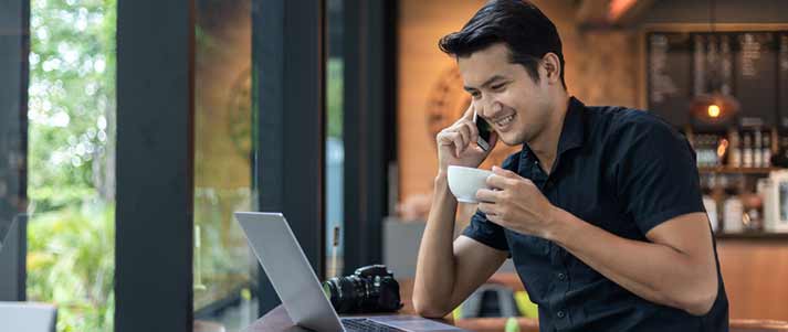 man working on phone in cafe