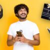 Man with phone, headphones, games controller, clapperboard and a book