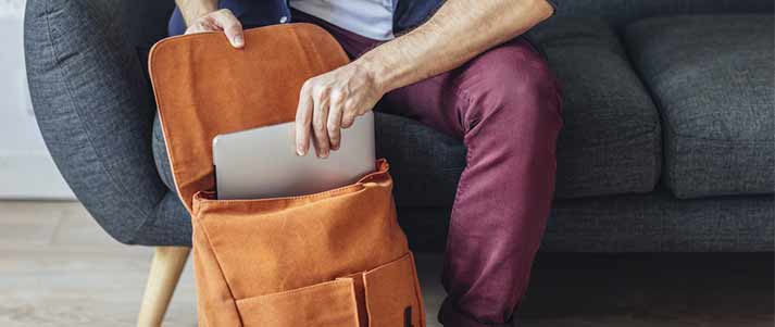 person packing laptop in bag