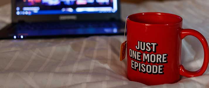 Mug on bed with laptop open