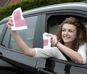 girl in car with l plate ripped